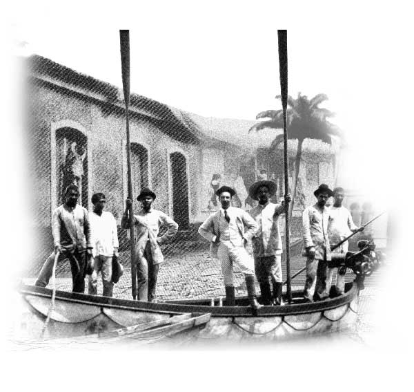 Esta imagem mostra quatro homens em pé dentro de um pequeno barco. Percebe-se que um deles, pela vestimenta, tem posses. Os demais estão vestidos de maneira simples.