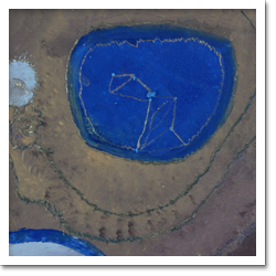 Esta tela com fundo em tons de cinza mostra, à esquerda, três círculos azuis de diferentes tamanhos. À direita, notam-se duas estrelas claras.