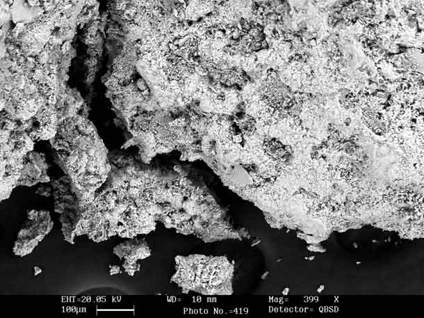 A fotografia mostra imagem microscópica de partículas em preto e branco.