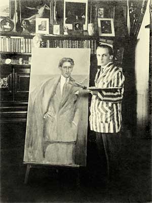 Foto em preto e branco mostra Portinari ao lado de uma tela – Retrato do Poeta Olegário Mariano. Ele está em pé, na diagonal, olhando para a câmera enquanto segura uma paleta de tinta com a mão esquerda. Veste paletó de grossas listras verticais e calça escura. A tela exibe, quase em tamanho real, a figura de um homem. Ao fundo da fotografia, há uma parede com vários quadros e objetos, além de uma estante com livros.