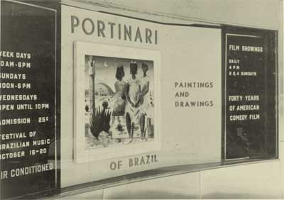 A fotografia está em preto e branco e exibe, em Inglês, a divulgação do trabalho de Portinari. Ao longo de uma parede, há duas faixas escuras nas laterais, onde há textos. Entre elas, destaca-se uma parte clara com o nome “Portinari” em letras grandes. Logo abaixo e ao lado, a imagem de uma das pinturas dele e as palavras “of Brazil” e “paintings and drawings”, que, em Português, significam, respectivamente, “do Brasil” e “pinturas e desenhos”. 