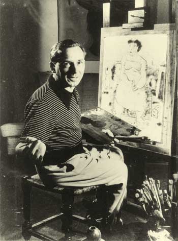 Foto em preto e branco de Cândido Portinari. O artista está sentado de frente para uma tela apoiada em um cavalete, na qual se percebe o desenho de uma mulher. Portinari olha para a câmera e sorri com os lábios entreabertos. Ele tem uma paleta de tintas na mão esquerda e um pincel na direita. No canto inferior direito, há vários pincéis de diversos tamanhos. 